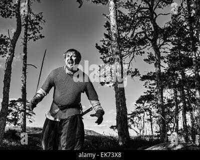 Guerrier viking médiéval portant cotte et il a l'épée, sur la nature du fond, image en noir et blanc Banque D'Images