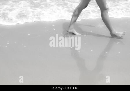 Jambes à pied sur le sable en noir et blanc Banque D'Images