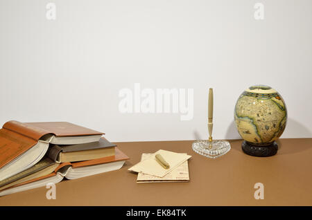 Jeu de lettres, porte-stylo, stylo en forme de coeur, petit globe et livres sur fond brun Banque D'Images