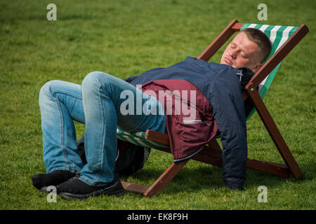 Londres, Royaume-Uni. Le 08 Avr, 2015. Endormie au soleil. Le soleil du printemps fait sortir les travailleurs et les touristes à l'heure du déjeuner. Ils vous détendre dans les chaises longues ou même les utiliser comme bureaux de plein air. Green Park, Londres, 06 mai 2015. Crédit : Guy Bell/Alamy Live News Banque D'Images