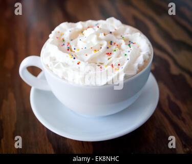 Un gâteau chaud avec latté et saupoudre de couleur crème fouettée de d'établir par Tish Café à Saskatoon, Saskatchewan, Canada. Banque D'Images