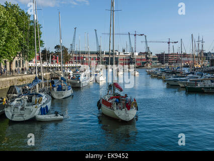 Yachts arrivant à Bristol's docks après une journée ensoleillée en mer. Banque D'Images