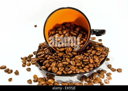 Tasse et soucoupe avec les grains de café isolated on white Banque D'Images