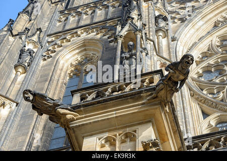 Deux gargouilles de la cathédrale Saint-Guy sur fond de la façade avec des sculptures en pierre, des fenêtres et des remplages, Prague, République Tchèque Banque D'Images