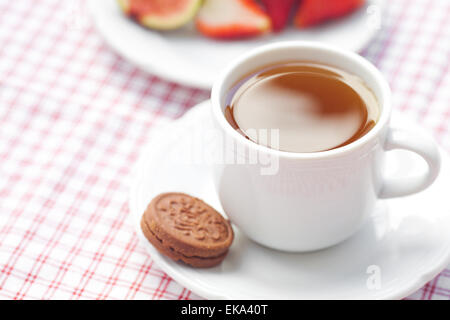 Tasse de thé, cookie, fig et les fraises sur une plaque Banque D'Images