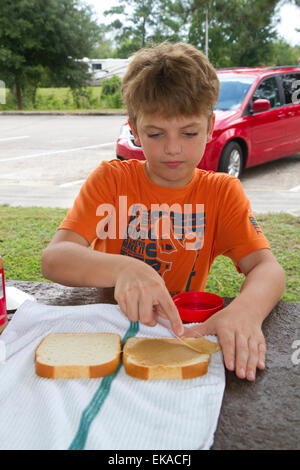 Garçon de dix ans de faire un sandwich au beurre d'arachide. Banque D'Images