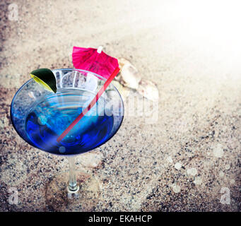 Fond de plage avec du sable de plage, rythme copie thème d'été, verre à cocktail avec parasol et une paille sur la texture du sable Banque D'Images