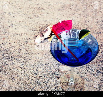 Fond de plage avec du sable de plage, rythme copie thème d'été, verre à cocktail avec parasol et une paille sur la texture du sable Banque D'Images