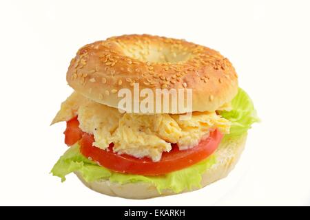 Bagel sésame avec des œufs brouillés, tomate et laitue. Studio isolated Banque D'Images