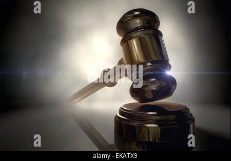 Un marteau en bois ordinaire les encanteurs ou juges gavel avec garniture de cuivre sur un fond noir rétroéclairé Banque D'Images