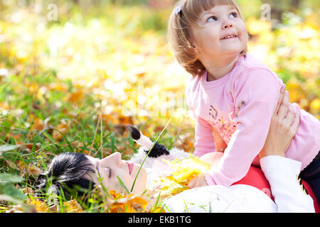 Belle jeune mère et sa fille se trouvant sur la partie de l'automne Banque D'Images