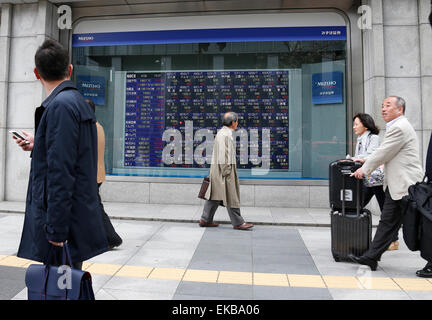 Tokyo, Japon. Apr 9, 2015. Les gens passent devant une carte électronique montrant l'indice boursier à Tokyo, Japon, 9 avril 2015. La question de 225 Nikkei Stock Average close à 19 937,72 jeudi. © Stringer/Xinhua/Alamy Live News Banque D'Images