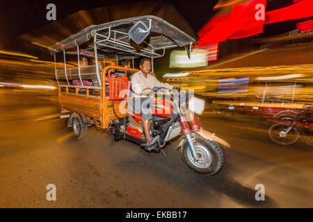 Photographie de nuit de tuk-tuk et conducteur dans la capitale de Phnom Penh, Cambodge, Indochine, Asie du Sud, Asie Banque D'Images