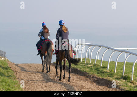 Arrière du cavalier de course jockey sur les routes de campagne dans le North Yorkshire Dales, Royaume-Uni avril 2015. Middleham possède maintenant ses propres gallerps en herbe et toutes saisons avec rail de course en plastique à crémaillère sur les Moors basse et haute. Middleham est établi comme un centre de formation de premier plan au Royaume-Uni où sont basés quinze formateurs. Les installations et la disposition ont continué à s'améliorer, permettant aux entraîneurs d'envoyer des athlètes en forme et de compétition et ont été récompensés par un succès supplémentaire au niveau supérieur. Banque D'Images