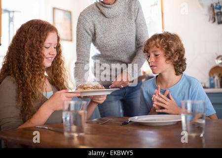 Mère servant à spaghetti enfants à la table à manger Banque D'Images