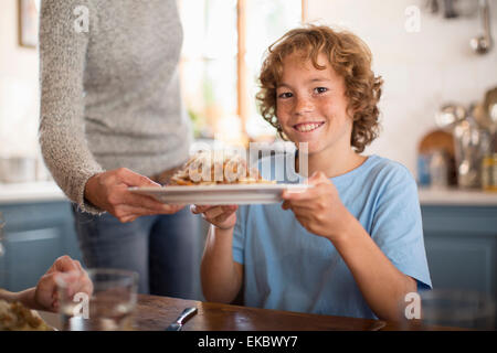 Mère servant à spaghetti enfants à la table à manger Banque D'Images