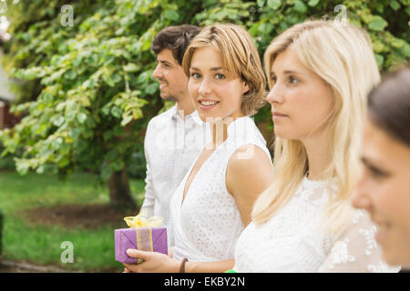 Portrait de jeune homme et trois femmes tenant le cadeau d'anniversaire dans le jardin Banque D'Images