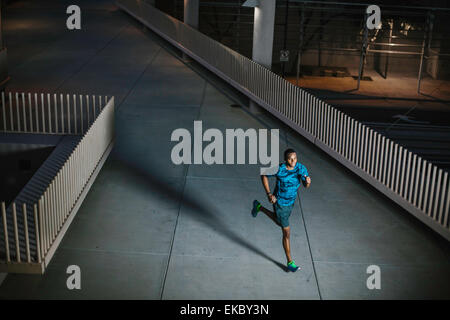 High angle view of young man running on city promenade de nuit Banque D'Images
