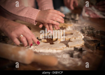 Couper des formes dans la pâte pour faire des biscuits Banque D'Images