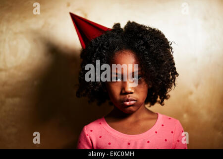 Sad girl wearing party hat Banque D'Images