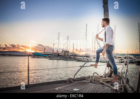 Young man relaxing on yacht, Cagliari, Sardaigne, Italie Banque D'Images