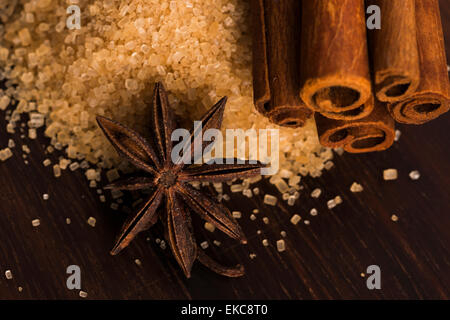 Des bâtons de cannelle avec du sucre brun de canne pur sur fond de bois Banque D'Images