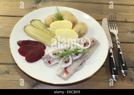 Une assiette de filet de hareng mariné, des pommes de terre, betterave et cornichons au Banque D'Images