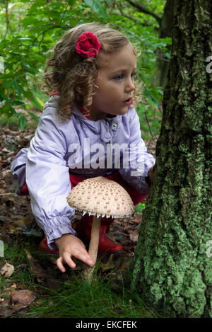 Jeune fille dans les bois cueillant des champignons, Italie Banque D'Images