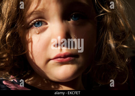 Portrait d'une fille triste avec des yeux bleus perçant pleurant Banque D'Images