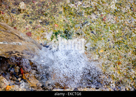 L'eau qui tombe en cascade dans l'eau peu printemps Banque D'Images