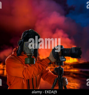 Le port d'un masque à gaz photographe en face de l'éruption de lave incandescente, Holuhraun site Volcan Bardarbunga, fissure, l'Islande Banque D'Images