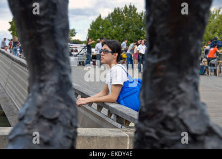 Paris, France- Young Asian Man s'arrêtant sur la passerelle de Solferino Pont sur la Seine. Banque D'Images