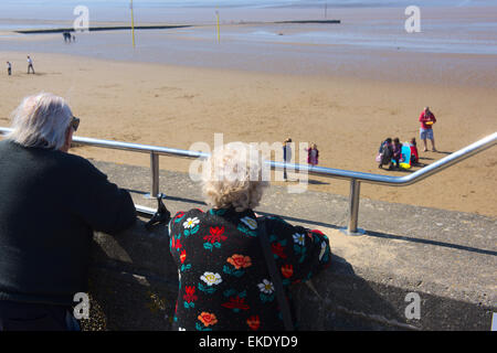 Vieux couple looking at family on beach de Burnham-on-Sea, Somerset Banque D'Images