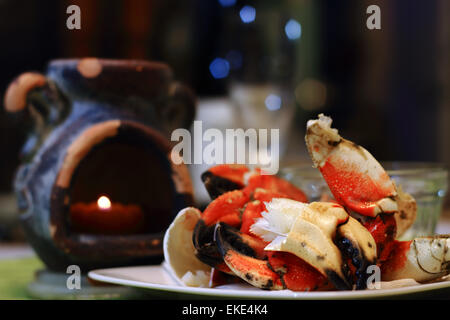 Pinces de crabe Jonah viandes succulentes montrant sur une assiette, avec la lumière de bougie et defocsed flûte en restauration des paramètres. Jonas cr Banque D'Images