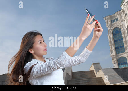 Les jeunes femmes japonaises aux cheveux longs n'afainst selfies city park en étapes et ciel bleu clair avec la lumière de brume, copyspace sur le ciel Banque D'Images