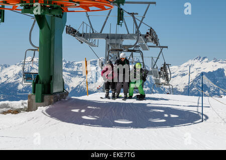 Un adulte et deux enfants qui quittent un ski-lift dans la station de ski de Verbier, Suisse Banque D'Images