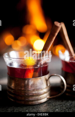 Vin chaud avec le bâton de cannelle par la cheminée Banque D'Images