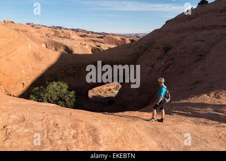 Apr 5, 2015 - Moab, Utah, États-Unis - vélo de montagne TIM LANE se trouve près de l'arc sur le grès rouge de slickrock Poison parcours araignée. Le Poison Spider Mesa trail est l'un des 'Must do' rides de Moab. La combinaison de défis exigeants physiquement cycliste avec une superbe vue, ce sentier est expert pour les motards. La piste peut être monté comme un retour, ou une boucle de 13 km qui comprend le fameux sentier Portail que le retour-route de la mesa. (Crédit Image : © Ruaridh Stewart/ZUMA/ZUMAPRESS.com) fil Banque D'Images