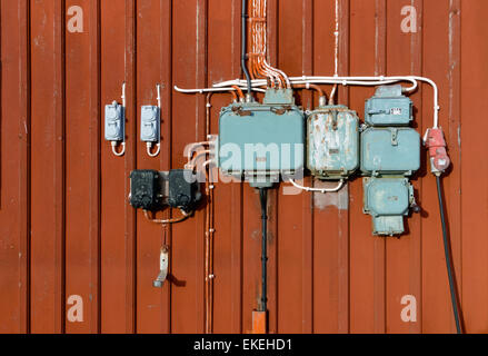 Style rétro de circuits électriques, prises et les boîtes de raccordement monté sur un mur en bois rouge Banque D'Images