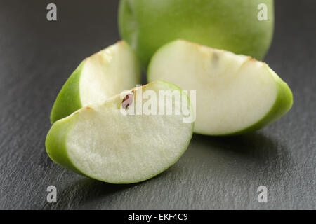 Pomme aigre sur ardoise vert tranchés conseil Banque D'Images