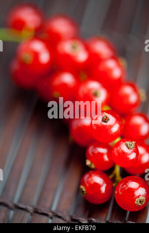 Succursale de groseille rouge sur un tapis de bambou Banque D'Images