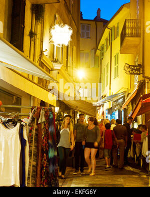 Les touristes visitent les magasins locaux dans le centre de la vieille ville de Cannes. La ville est célèbre pour ses hôtels de luxe un Banque D'Images