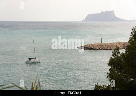 Un yacht à entre dans le port de Moriara sur la Costa Blanca en Espagne, avec en arrière-plan d'Ifach Banque D'Images