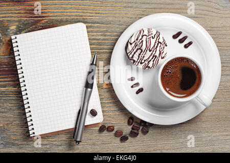 Tasse de café avec biscuits et crème ouvert le bloc-notes sur la vieille table en bois. Vue d'en haut Banque D'Images