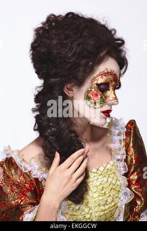 Faceart. Masque de Venise. Belle femme en robe d'époque et un masque sur son visage. Regardant à droite. Banque D'Images