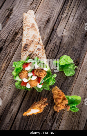 Languettes de poulet avec de la laitue Tortilla sur le bois. Banque D'Images