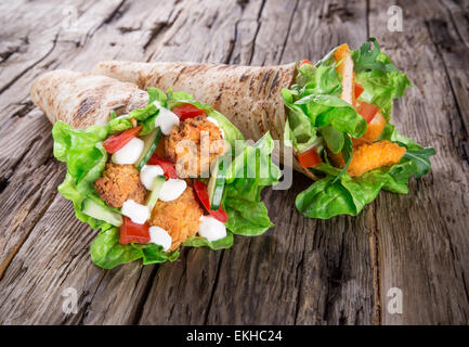 Languettes de poulet avec de la laitue Tortilla sur le bois. Banque D'Images