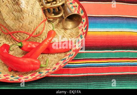 Sombrero mariachi fiesta mexicaine poncho tapis fond chilis dans des couleurs vives avec copie espace Banque D'Images