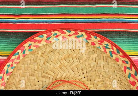 Fiesta Mexicaine traditionnelle poncho tapis de couleurs vives et de l'arrière-plan avec copie espace sombrero Banque D'Images