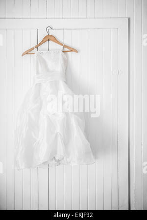 Classic Flower Girl Dress accroché sur un mur blanc Banque D'Images